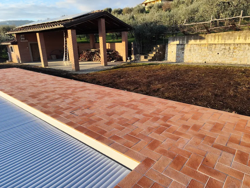 Bordo piscina in cotto a spina di pesce, tra gli olivi