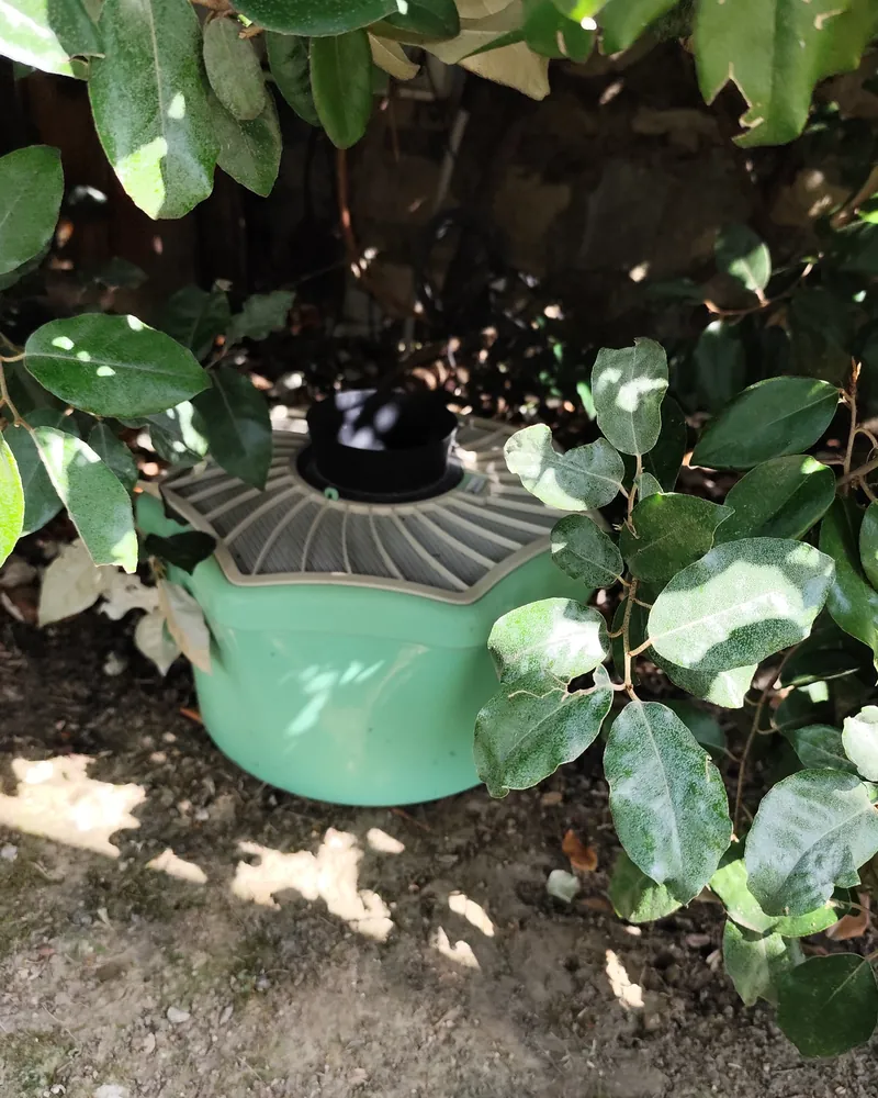 Trappola antizanzare verde a CO₂ sotto le foglie di una siepe